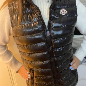 Svart ”Gui” dunväst från Moncler - Säljer nu min lilla systers svarta ”Gui” dunväst från Moncler. Jackan är Unisex (tror igentligen att den är dam). Kom gärna privat angående mer bilder samt frågor om västen!💕🙌