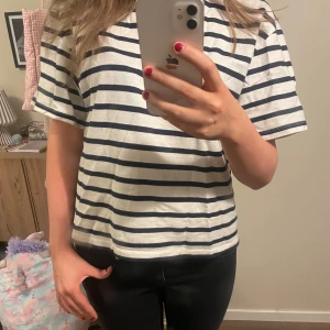 Randig t-shirt - Säljer en vit och blå randig t-shirt med korta ärmar. Perfekt för en avslappnad stil. Passar bra till jeans eller shorts🧡