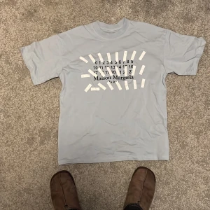 Maison margiela Ljusblå t-shirt  - Snygg t-shirt av Maison margiela. Säljer då den inte passar. Den är i storlek S men sitter större mer kanske M. Vid intresse tveka inte på att skriva! Pruta ska nog gå