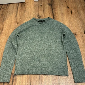 Grön stickad tröja från Vero Moda - Säljer en stilren grön stickad tröja från Vero Moda Perfekt för kyligare dagar med sin mjuka och bekväma passform. Tröjan har långa ärmar och en klassisk rund halsringning. Passar bra till både jeans och chinos.