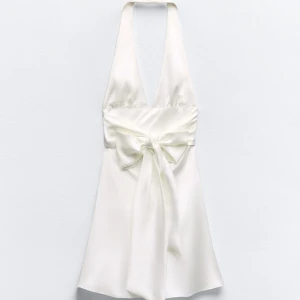 Vit satin klänning från Zara - Elegant vit klänning från Zara i satin. Klänningen har en vacker knytning baktill och en djup v-ringning. Den har några enstaka defekter där jag sytt in klänningen innan men dem är uppsprättade. (Ingenting som syns från långt håll)  Annars är den perfekt🤍 Strl XS