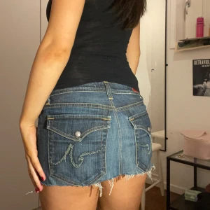 Jeanskjol - Så snygg jeanskjol med coola fickor!! Köpt second hand men är i fint skick förutom att den är avklippt längst ner. Midjemått: 39cm, längd: 27cm.