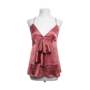 Rosa satinlinne  - Elegant rosa satinlinne med smala axelband och volangdetalj framtill. Toppen har en v-ringad design och korsade band i ryggen för en stilren look. Uppklätt tillfälle. Storlek 40 men passar S & M med! 