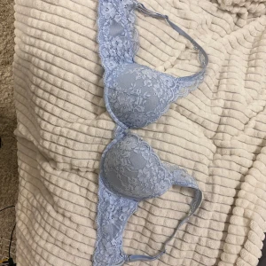 Ljusblå spets-bh - Elegant ljusblå bh med vacker spetsdetaljering. Den har vadderade kupor och justerbara axelband för optimal passform. Perfekt för att ge en romantisk touch till din garderob.