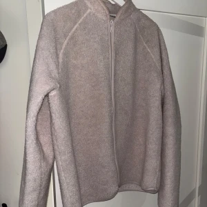 Beige fleecejacka från Weekday - Mysig beige fleecejacka från Weekday med dragkedja framtill. Perfekt för kyliga dagar med sin mjuka och varma känsla. Jackan har en enkel design med långa ärmar och en hög krage. Ganska oanvänd men är perfekt för vår och höst✅ 