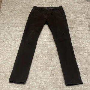 DONDUP chinos - Snygga bruna byxor från Dondup i en klassisk design. Byxorna har en rak passform med knappar och bälteshällor. Perfekta för en stilren look.
