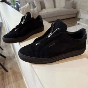 Svarta sneakers från Axel Arigato - Snygga svarta sneakers från Axel Arigato i mocka med dragkedja. Inte använd så många gånger utan mest i finare tillfällen. Mycket bra skick arigstos har i både storlek 41 och i 44. Ordinarie pris 2250kr
