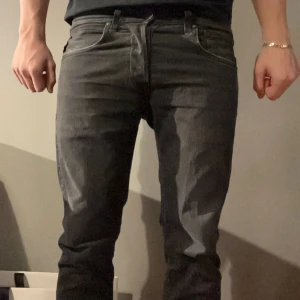  Replay jeans - Snygga svarta jeans från Replay med en klassisk femficksdesign. De har en slim passform och är tillverkade i ett slitstarkt material. Perfekta för en stilren look.