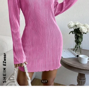 Rosa ribbad klänning från SHEIN - Snygg rosa klänning från SHEIN med ribbad textur och långärmad design. Perfekt för en stilren look. Klänningen har en figurnära passform som framhäver silhuetten.
