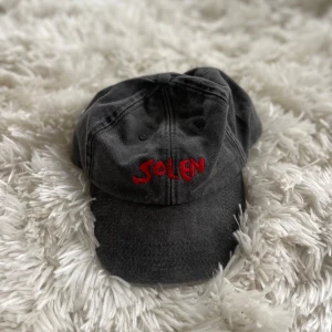 Grå keps med röd brodyr ”solen” - Snygg grå vintage keps med röd broderad text 'SOLEN' framtill. Såldes som merch till bandet Solen. 