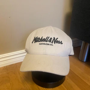 Beige keps från Mitchell & Ness - Snygg beige keps från Mitchell & Ness med justerbar rem baktill. 
