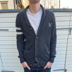 Stickad kofta Fabilion - Säljer en snygg grå kofta från Fabilion. Skick 8.5/10 toppskick utan synliga defekter. Nypris ligger runt 1700kr men säljs nu för endast 599kr. Hör görna av er vid funderingar!