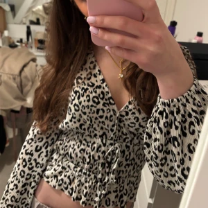 Leopardmönstrad blus - Snygg leopardmönstrad blus med knytning framtill. Blusen har långa ärmar och en smickrande v-ringning. Perfekt för att ge en trendig touch till din outfit❤️