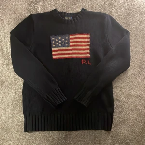 Polo Ralph lauren flag sweater - Tja! Säljer den här efterfrågade och riktigt snygga Polo Ralph lauren flag sweatern•Färg marinblå•Skick 9/10 inga defekter alls på tröjan•Storlek XS/ ungdom 14-16•Nypris ca 4000kr hos oss endast 1699kr• Hör av er vid minsta lilla fråga eller fundering! 