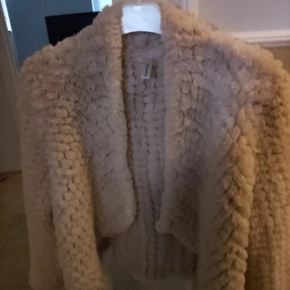 Mysig beige teddyjacka med långärmad design. Perfekt för att hålla värmen under kyliga dagar. Jackan har en fluffig och mjuk textur som ger en trendig look.. Takit.