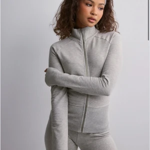 Grå zip-up tröja - Populär Snygg och bekväm grå zip-up tröja från Nelly . Perfekt för en avslappnad stil. Tröjan har en dragkedja framtill och ribbade detaljer vid ärmslut och nederkant. Aldrig använd 