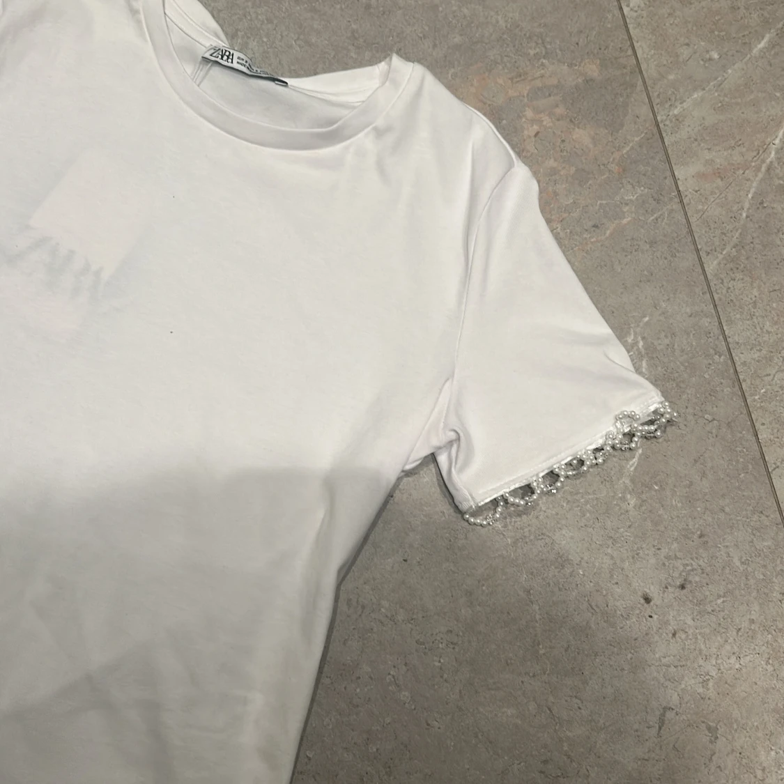 Vit t-shirt med pärldetaljer från Zara