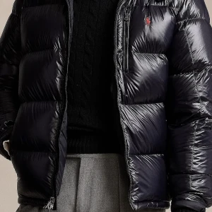 Svart dunjacka från Ralph Lauren - Snygg svart dunjacka från Ralph Lauren med en quiltad design och dragkedja framtill. Jackan har en liten röd logotyp på bröstet och en praktisk huva. Perfekt för kyliga dagar! Möta bara upp och tar bara kontanter jackan kommer i oöppnad originalförpackning och kvitto finns köpt för 6000kr