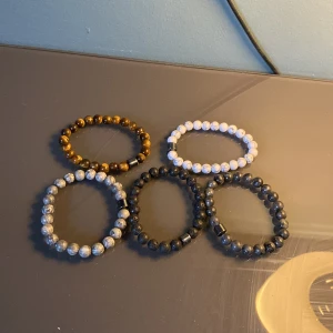 Färgglada pärlarmband i olika stilar - Säljer set med  pärlarmband i olika färger och stilar. Armbanden har elastiska band och är dekorerade med pärlor i svart, vitt, brunt och grått. Perfekt för att mixa och matcha efter humör och stil.1=50. 2=85. 3=125. 4=160. 5=180