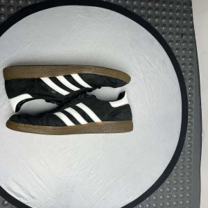 Adidas Spezial - Snygga svarta Adidas Spezial för dig som vill ha en stilren relaxed stil. Lite slitet skick, men har fortfarande mycket liv kvar i sig. Populär modell. storlek 44 2/3.          Nypris: 1200kr         Vårt pris: 399kr