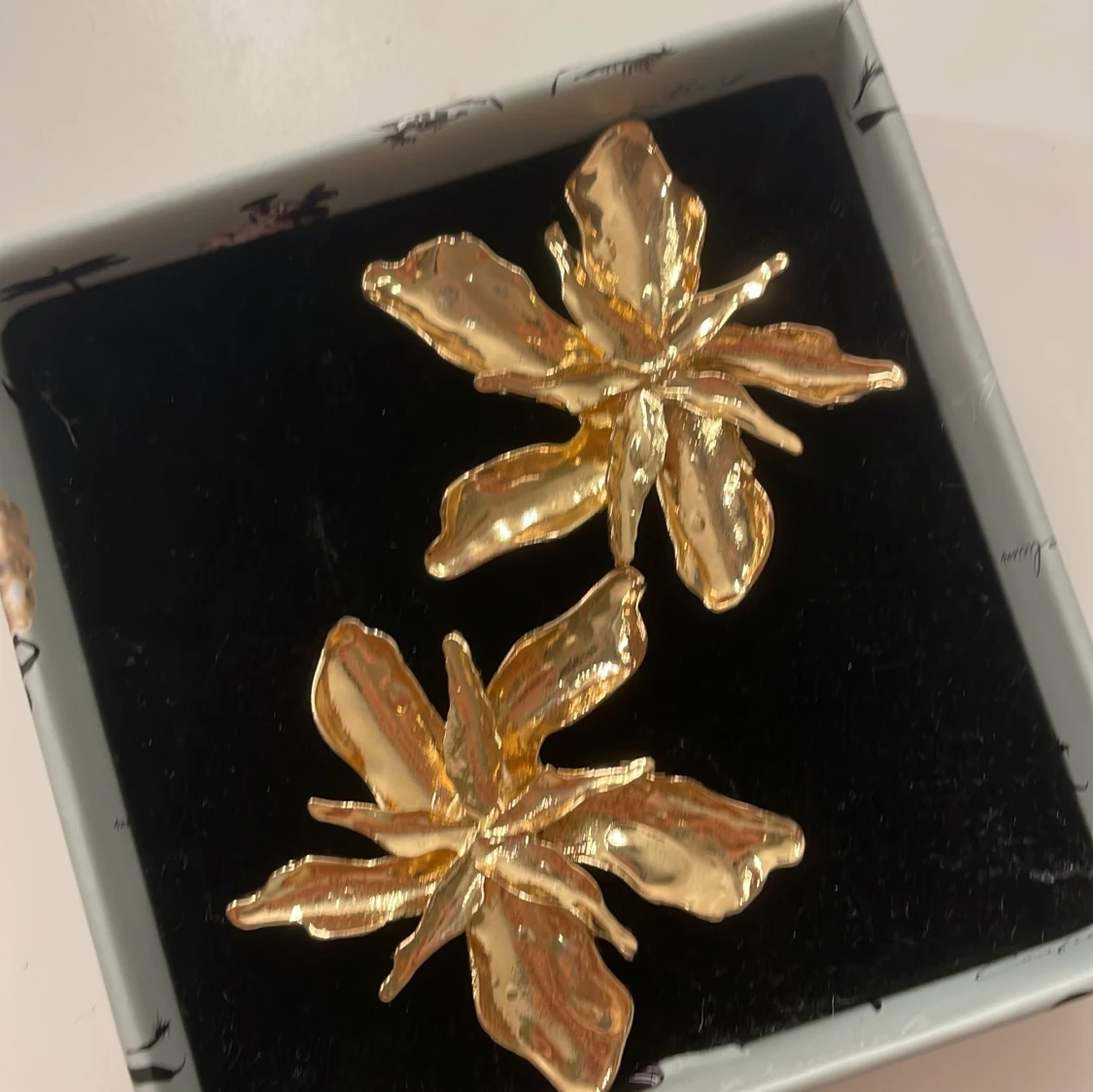 Guldiga blomformade örhängen