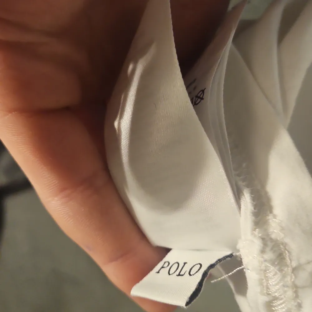 Säljer en vit t-shirt från Ralph Lauren med ett stort, färgglatt tryck av en polospelare i blått, rött, grönt och gult. T-shirten har en klassisk passform och är perfekt för en avslappnad stil. Märket 'Polo' syns tydligt på etiketten. STRL S!!. T-paidat.