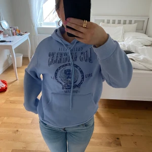 hoodie - Säljer en ljusblå hoodie med tryck på framsidan. Inte använd mycket !