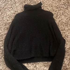 Svart stickad tröja med krage - Mysig svart stickad tröja med en krage. Mysig för vintern 
