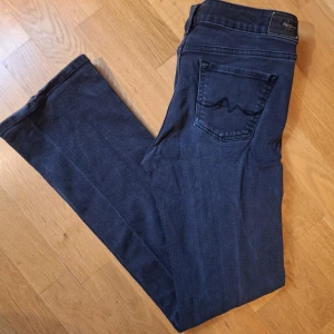 Svarta bootcut jeans - Jättefina svarta bootcut jeans från pepe! Står att de ska vara mid waist men tycker själv att dem är mer low waist.  Fint skick förutom lite slitningar på slutet av benen, inget märkvärdigt dock.  Är runt stl S - M skulle jag säga.  Midjemått tvärs över: 38 cm ish Innebenslängd: 78 cm ungefär