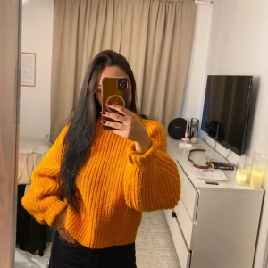 Orange stickad tröja - Säljer en mysig orange stickad tröja med långa ärmar och en oversized passform. Perfekt för höst och vinter, den är både varm och stilren. Tröjan har en ribbad struktur som ger den en extra touch av stil. Passar perfekt till jeans eller kjol för en avslappnad look.