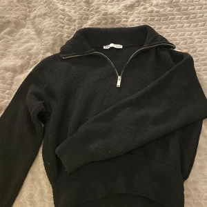Svart stickad tröja med dragkedja - Säljer en svart stickad tröja från Zara med dragkedja vid halsen. Stretchig i materialet!