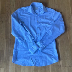 Blå rutig skjorta från Bruun & Stengade - Snygg blå rutig skjorta från Bruun & Stengade i slim fit aldrig använd. Säljer den då den är för stor för mig. Storlek 41, passar dig som har storlek L. Tveka inte att skriva vid minsta fråga!😁💯