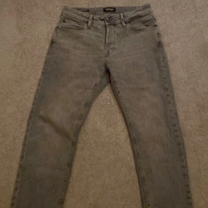 Grå jeansbyxor - Snygga grå jeansbyxor med klassisk femficksdesign. De har en rak passform och är tillverkade i slitstarkt denim. Perfekta för en avslappnad stil.