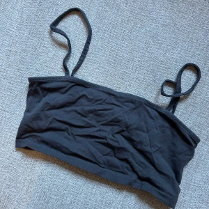 Svart tubtopp med axelband - Snygg grå tubtopp med smala axelband. Perfekt för varma dagar eller som ett lager under andra plagg. Enkel och stilren design som passar till det mesta.