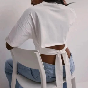 Topp - Säljer denna trendiga toppen från Nelly med knytning baktill!! Endast använd en gång💗