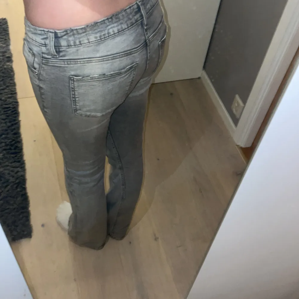 Säljer ett par snygga grå jeans med bootcut. De är lågmidjade och i jättebra skick!. Jeans & Byxor.