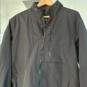 Haglöfs jacka - En skal/hardshell jacka från haglöfs i mycket bra skick. Size Large. Säljes då den är för stor för mig. Den har en ihopfällbar luva och flera fickor.  Bara att skriva vid fler funderingar:)