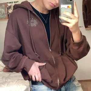 Brun hoodie med tryck på ryggen  - Bra skick