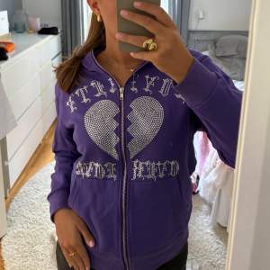 Lila hoodie med stenar, har dragkedja hela vägen upp. I storlek XS men sitter mer som en S🤗  (Viktigt att den tvättas ut och in för att stenarna inte ska ramla av!)