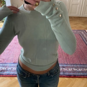 Ljusgrön långärmad topp - Jättefin topp perfekt till hösten! Sjukt fin färg! Gulddetaljer längst ut på ärmarna. 