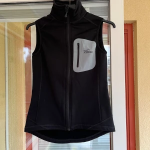 Svart väst från Tierra - Säljer en svart väst från Tierra. Västen har en dragkedja framtill och en praktisk bröstficka med dragkedja. Perfekt för utomhusaktiviteter. Den är gjord i Polartec Power Stretch Pro. Tierra-products.com  Köpt för 999kr.