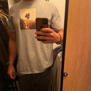 Grå t-shirt med tryck - Säljer en grå Travis scott merch i storlek M men passar M/L. Är använd ett fåtal gånger och har iga skador eller missfärgningar, skick 9/10. Kom med bud eller skriv frågor vid funderingar.