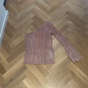 Rosa skimrig tröja med en ärm - Den är i bra skick bara använd en gång 
