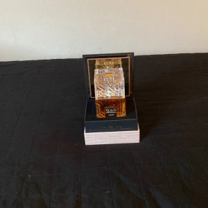 Khamrah Eau de Parfum från Lattafa - Säljer en lyxig Khamrah Eau de Parfum från Lattafa. Flaskan är elegant och fyrkantig med ett detaljerat mönster i glaset. Den har en gyllene färgton som ger en känsla av exklusivitet. Parfymen är tillverkad i UAE och kommer i en snygg förpackning som gör den perfekt som present eller för att skämma bort sig själv. Perfekt för den som älskar orientaliska dofter!