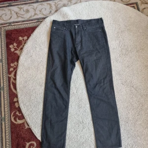 Svarta byxor i bomullsblandning - Säljer ett par svarta byxor i en skön bomullsblandning. De har en klassisk straight fit och är tillverkade i 52% bomull, 23% polyester, 23% viskos och 2% elastan. Perfekta för både vardag och lite mer uppklädda tillfällen.