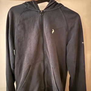 Mörkblå peakperformance zip hoodie - Mörblå zip från peakperformance. Säljer den pågrund av att den blivit för liten för mig.