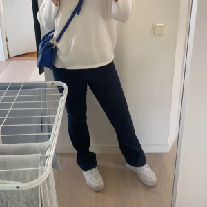 Marinblå kostymbyxor  - Säljer dessa mörkblå kostymbyxor i mycket bra skick🤗 De är bootcut med låg/medel midja och knappar framtill som överlappar lite och knäpps snyggt lite till sidan!🤩 Perfekta till många olika tillfällen. Passar bra till en vit skjorta/topp eller en stickad tröja💕💕💕