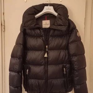   dunjacka från Moncler i storlek M/L  - Säljer en snygg svart/mörk mörk blå  dunjacka från Moncler i oanvänt skick/mycket bra skick  då jag bara använt den 2-3 gånge.  Jackan har en dragkedja framtill och långa ärmar. Perfekt för kalla vinterdagar med sin varma och puffiga design. Kvittot får man med för jackan. Köpt för 18900 men säljer för 15500för den är helt ny pris kan dock tänka mig sänka priset. Sitter väldigt figurnära passform.