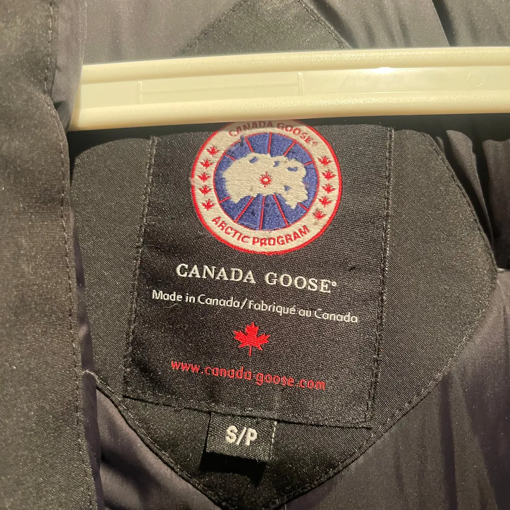 Säljer en svart parkajacka från Canada Goose i mycket bra skick. Jackan har en pälsfodrad huva och är perfekt för kalla vinterdagar. Den har långa ärmar och flera praktiska fickor. Perfekt för dig som vill hålla dig varm och stilren i vinter! ❄️. Jackor.