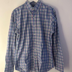 Ralph Lauren skjorta  - En blåvitrutig skjorta från Ralph Lauren med en liten gul polospelare på bröstet. Skjortan har en slim fit och är långärmad. Fint skick. Storlek M